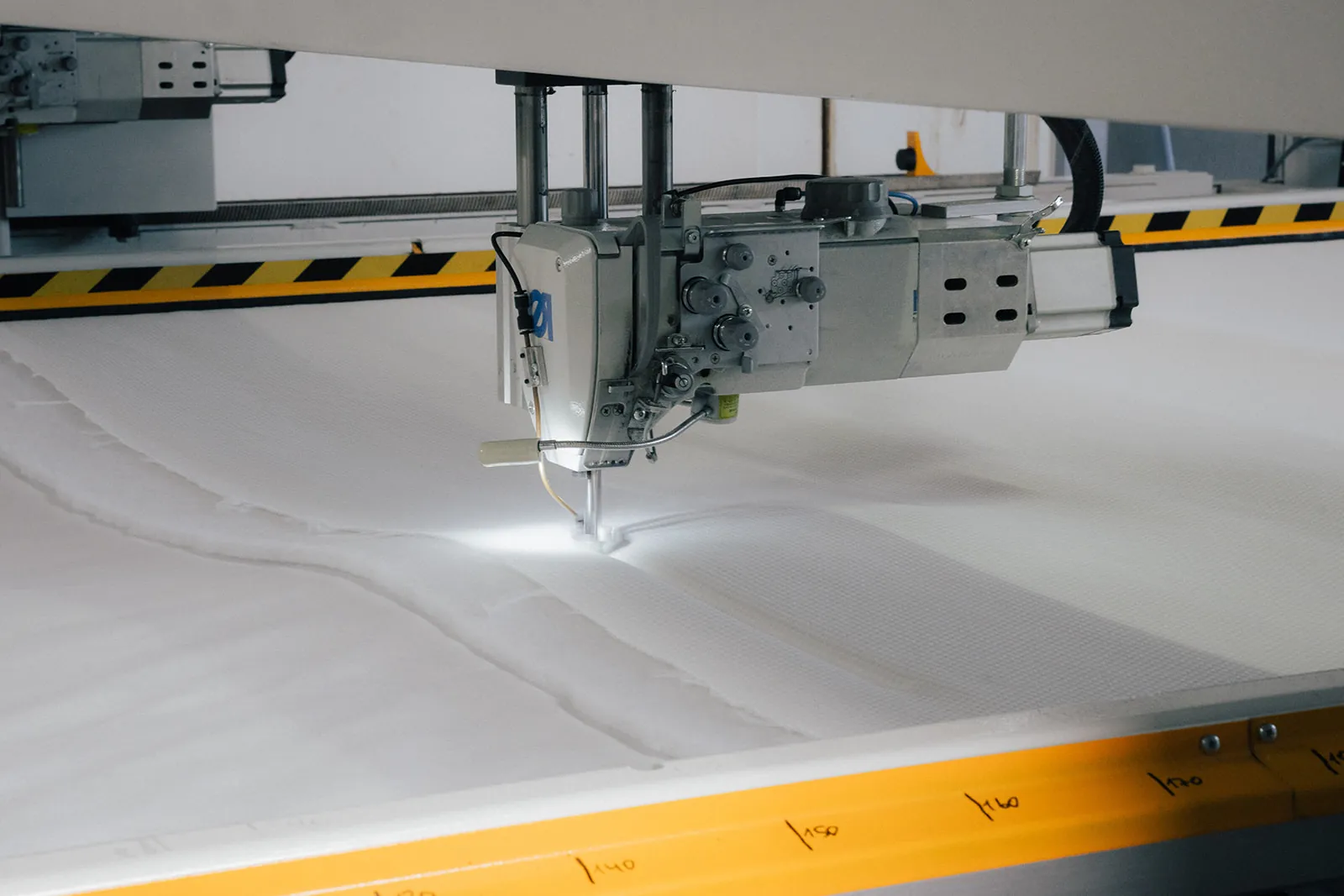 Nähkopf der Steppanlage über dem Bezugstoff, Nähmaschine,  Quiltarbeit,  Stoffschneide,  Industriemaschine,  Bedienfeld